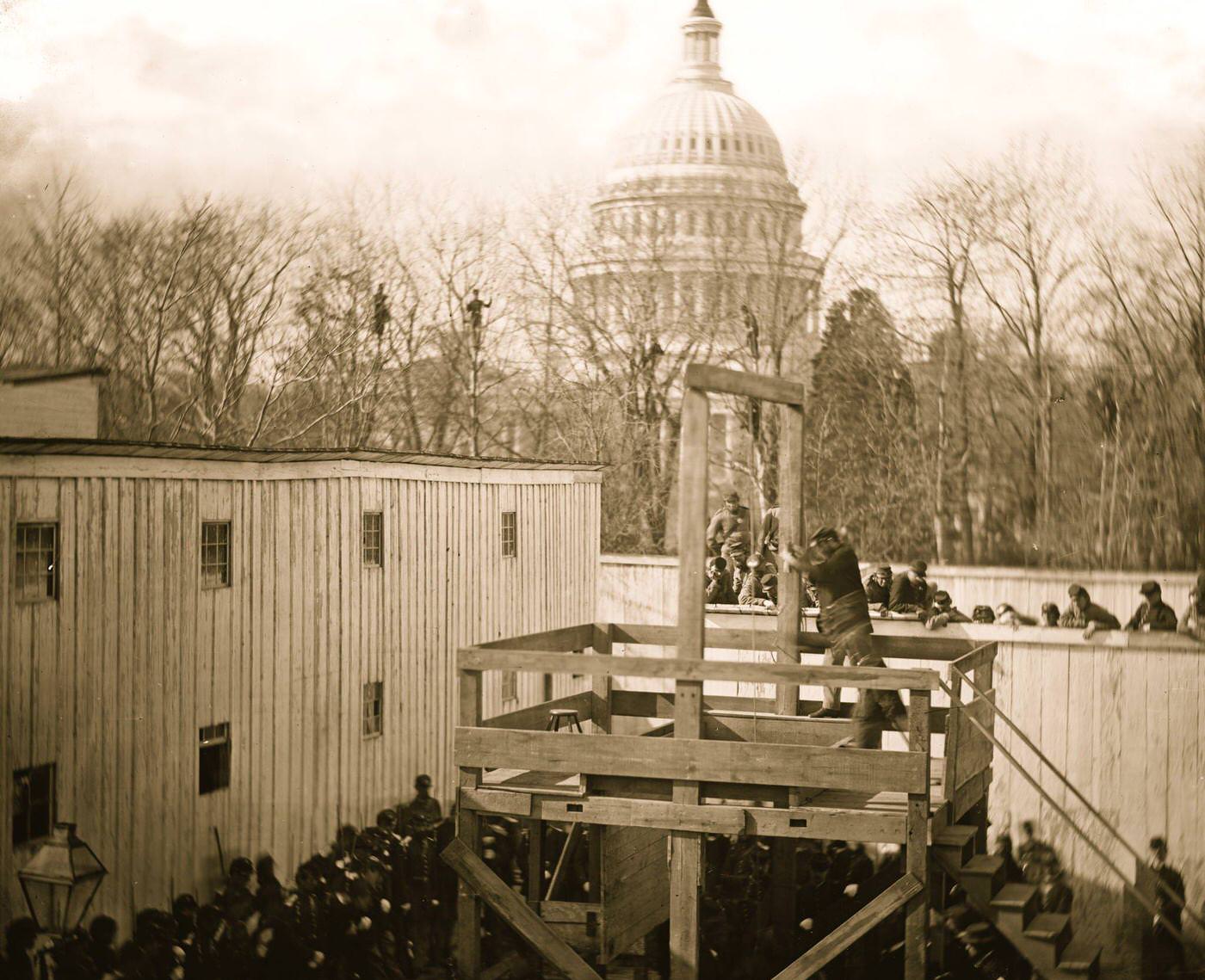 Washington, D.C. Soldier springing the trap; men in trees and Capitol dome beyond, 1865