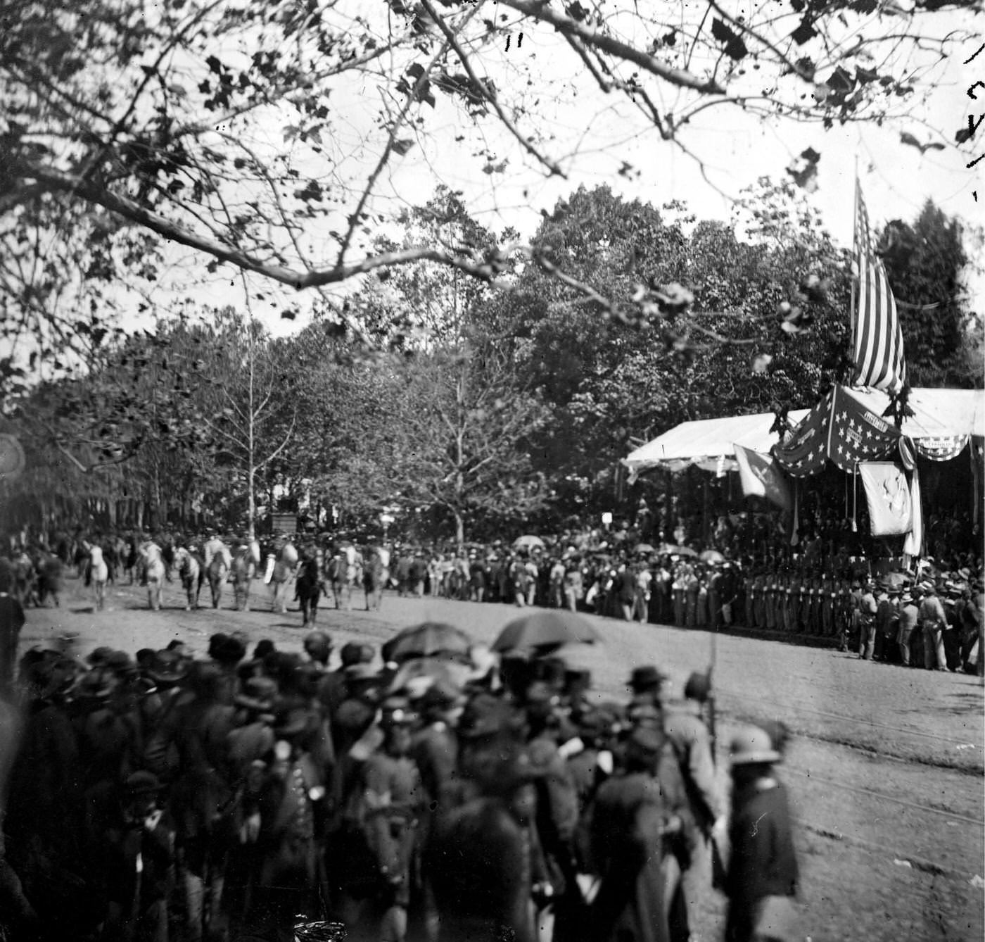 Cavalry unit passing the Presidential reviewing stand, with guests and guard, during the "grand review" of the Union Army, Washington, D.C., 1865