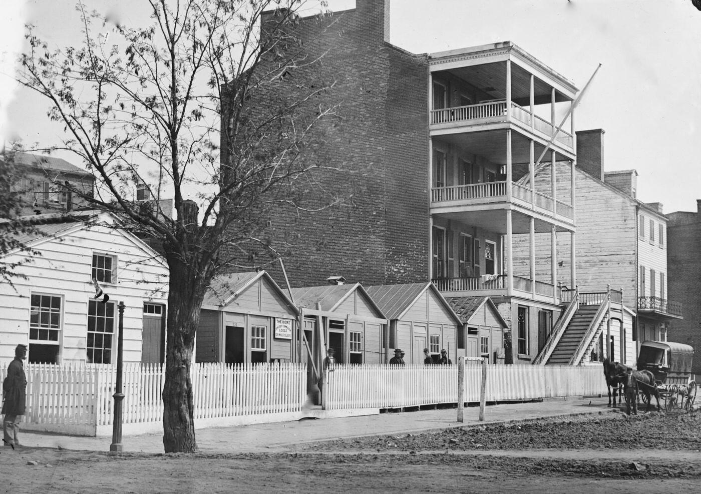 The street and exterior of buildings belonging to the Sanitary Commission Home Lodge for Invalid Soldiers, located on North Capitol near C Street, Washington, D.C., 1865