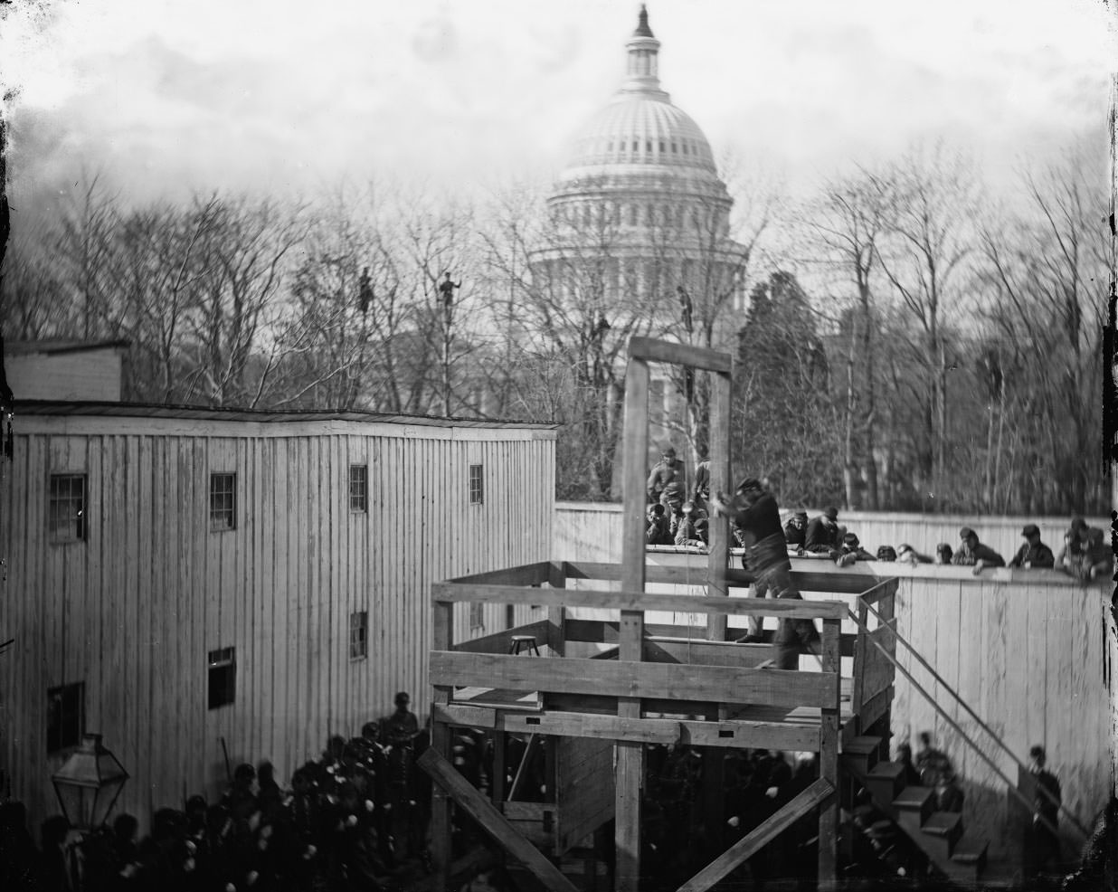 Washington, D.C. Soldier springing the trap; men in trees and Capitol dome beyond, 1865