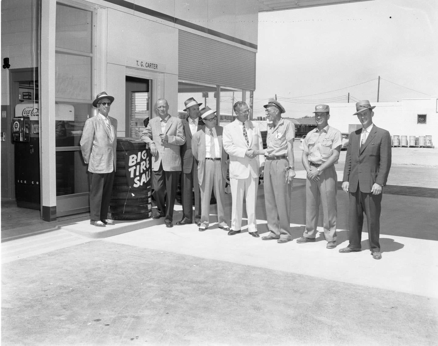 Men standing outside the Magnolia's Station auto shop on S. First St. in Abilene, 1956