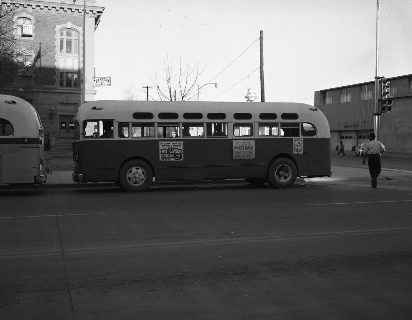 A bus stopped at a bus stop near an intersection in downtown Abilene, 1955