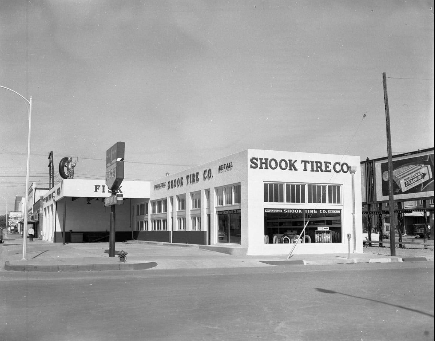 An exterior view of a building identified as Shook Tire Company on Oak Street in Abilene, 1958