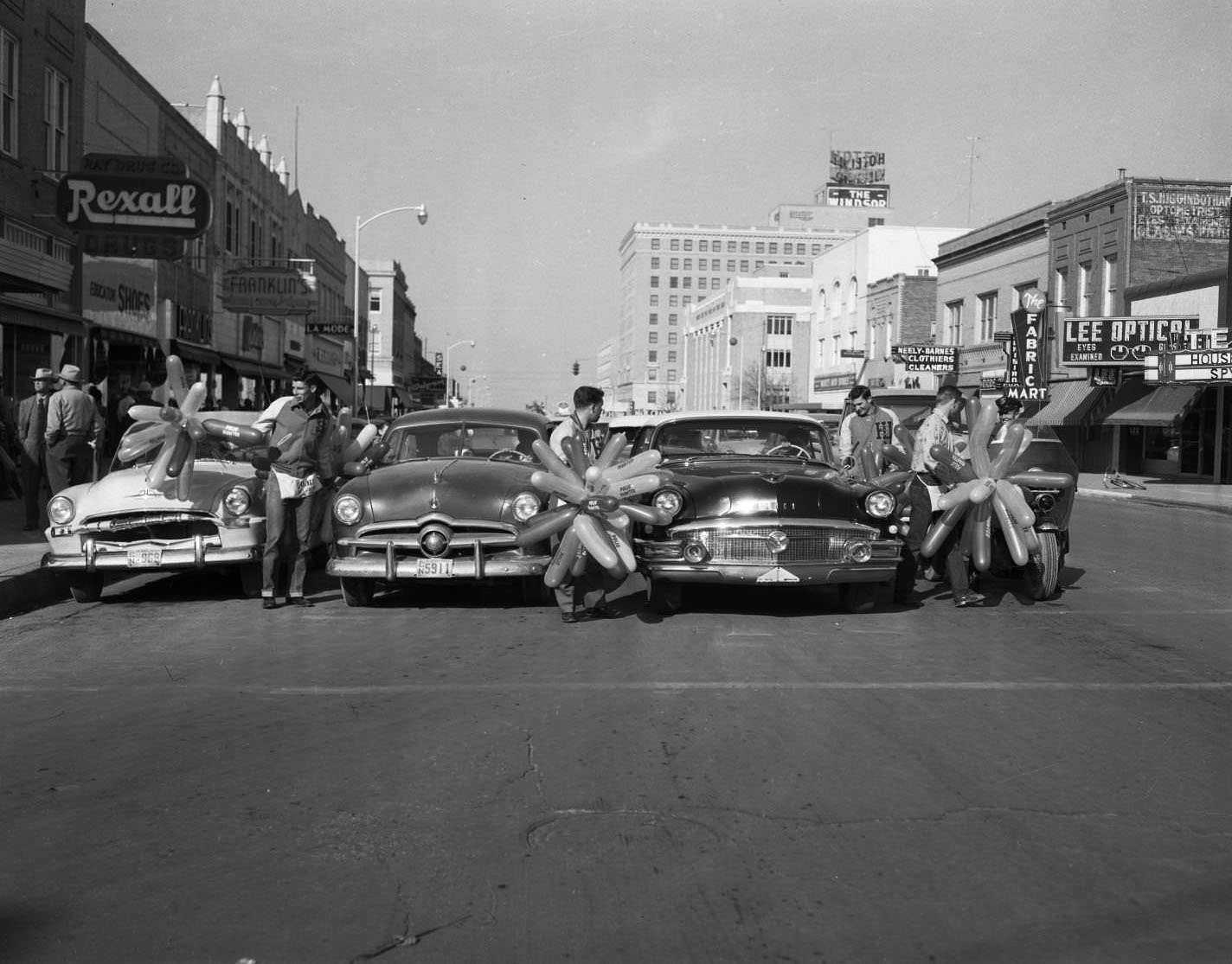 Young men handing polio drive balloons to passing motorists in Abilene, 1955