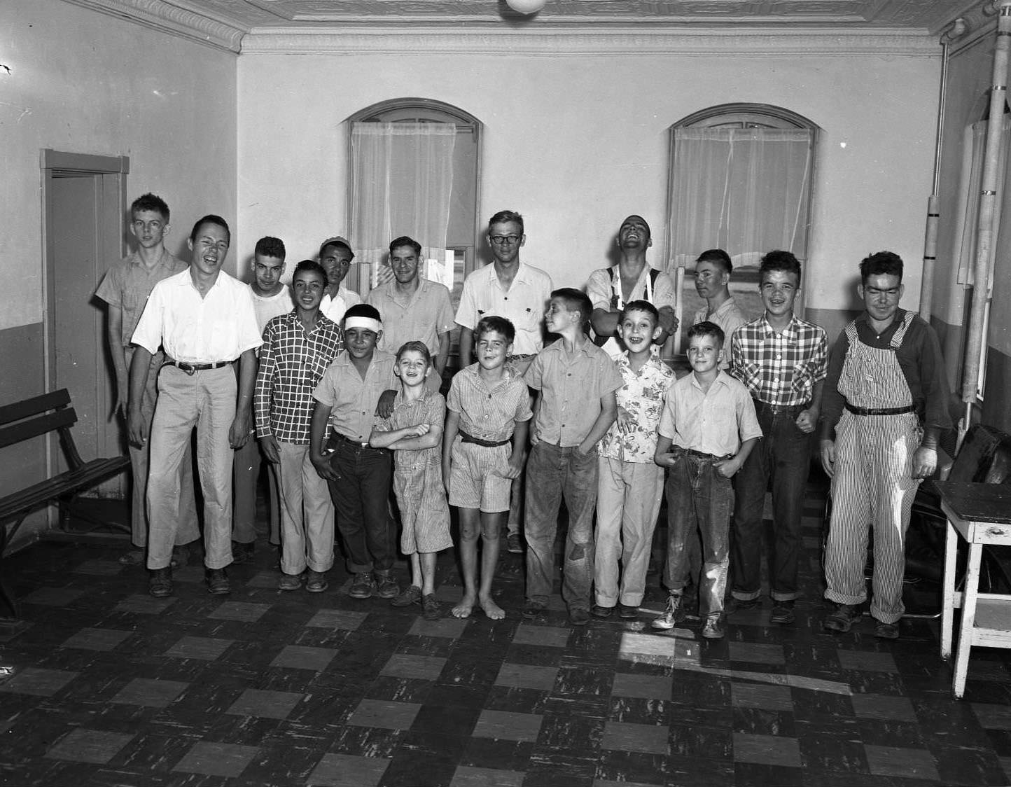 A group of boys at the Abilene Boys Ranch. The boys are standing in two rows in a mostly empty room. The younger boys stand in the first row.