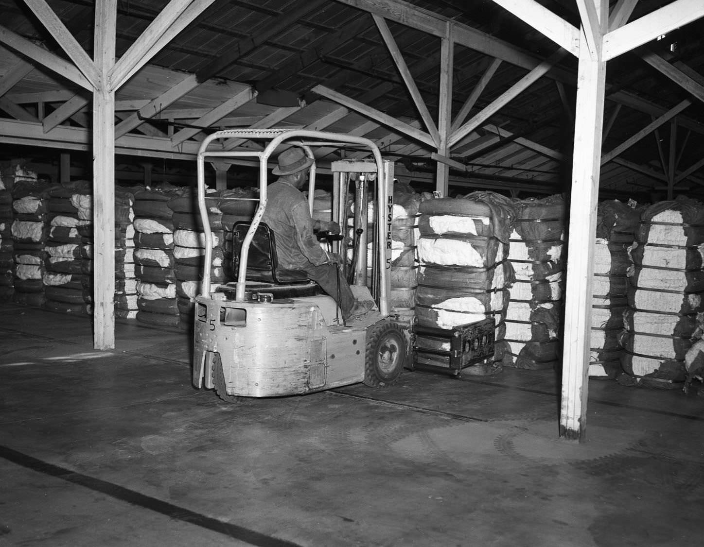 A man loading a forklift with compressed cotton in Abilene, Texas, 1956