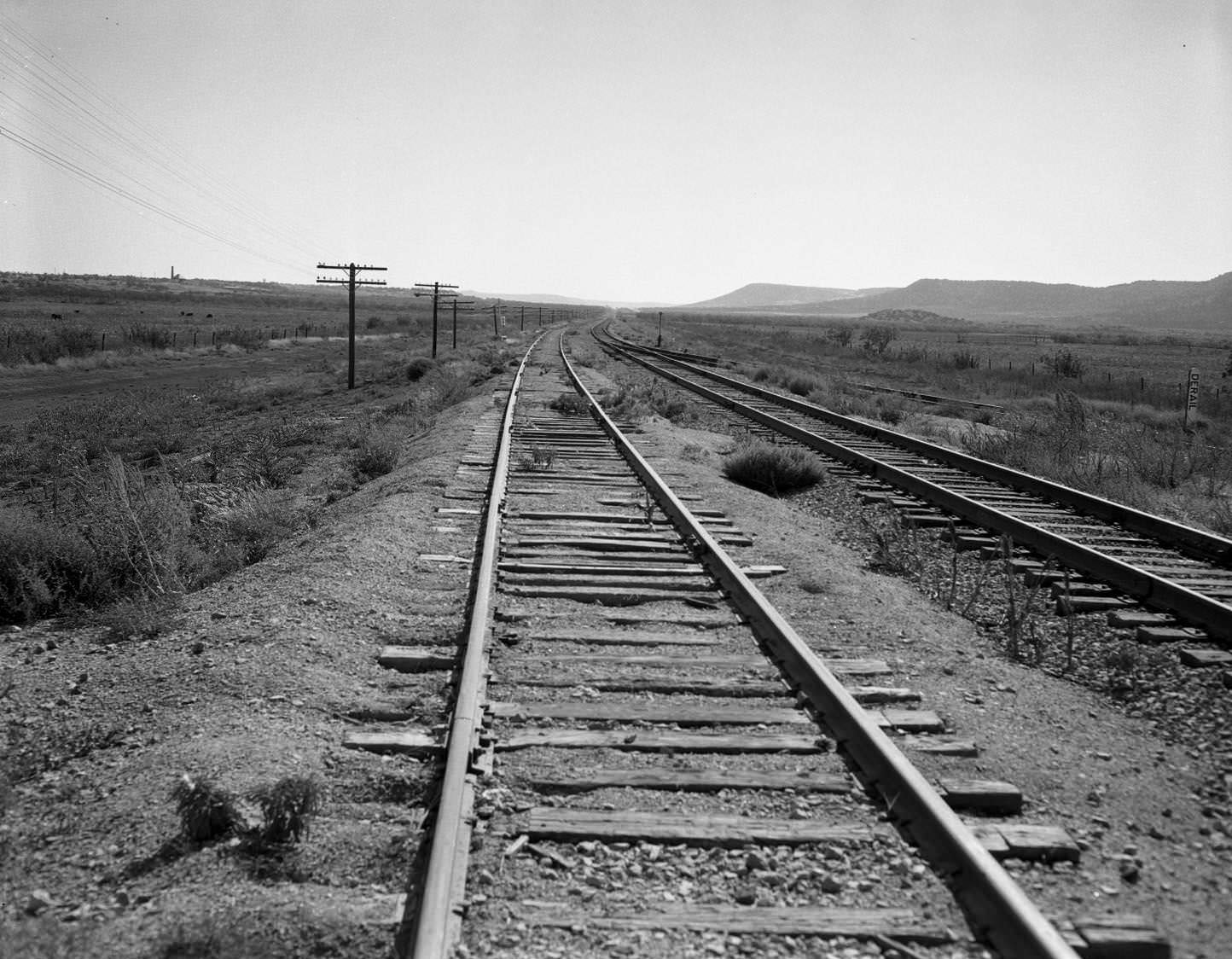 Two sets of train tracks in the desert, 1955