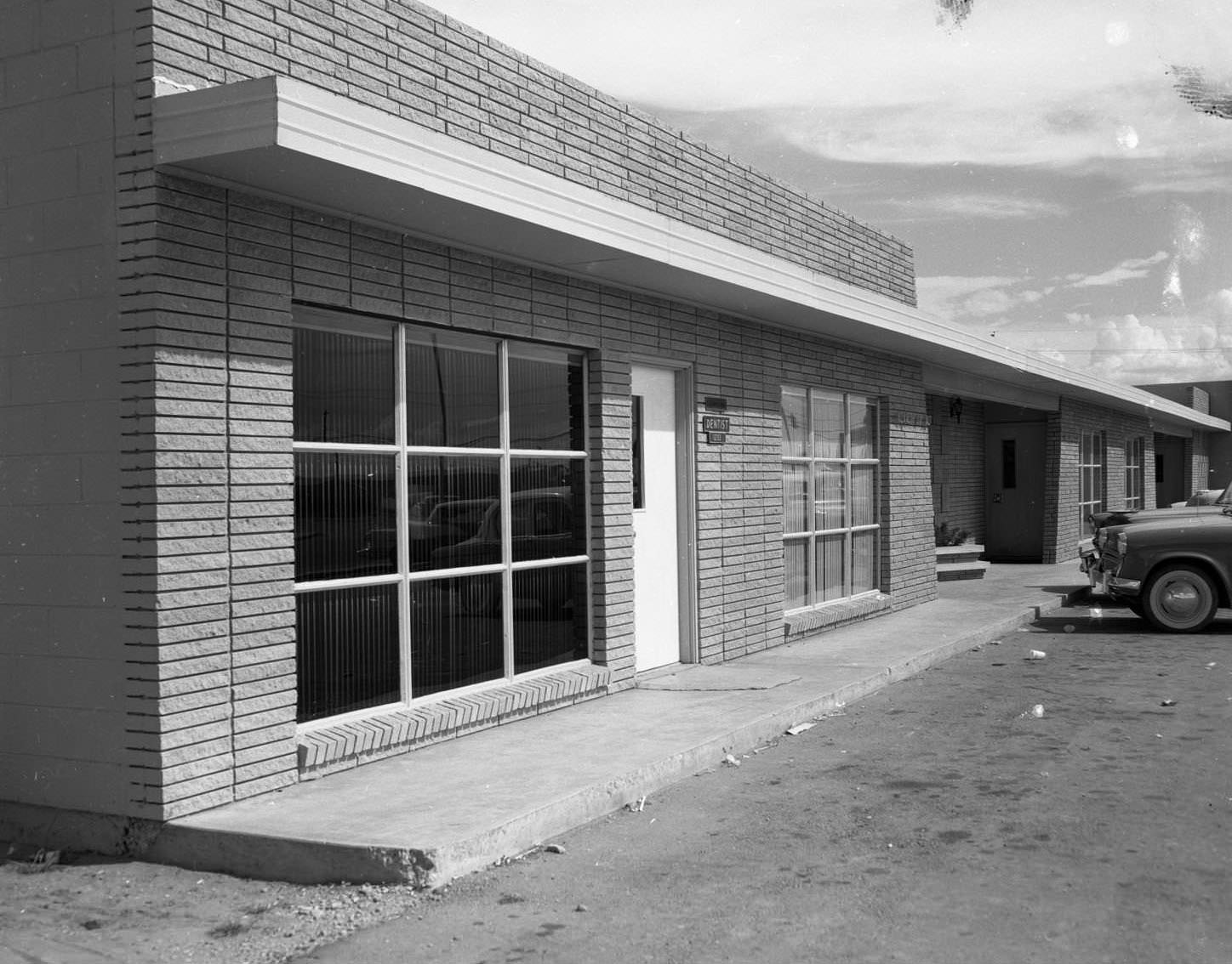 An exterior view of a brick building identified as Doctor Fox's Office, 1959