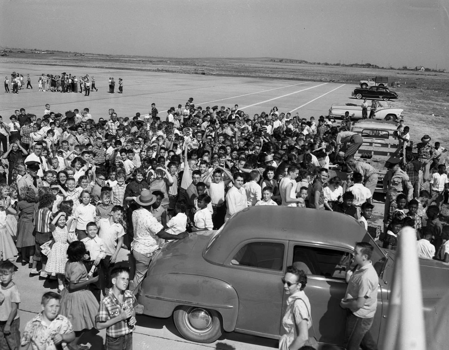 A large crowd men, women and children standing on a runway at the Dyess Air Show in Abilene, Texas, 1955