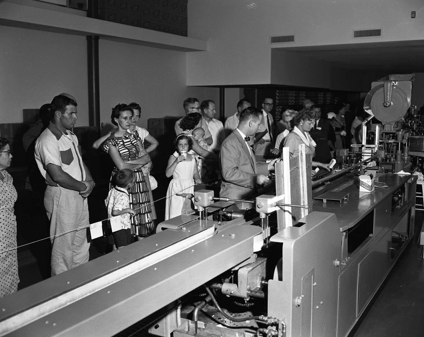 A line of men, women, and children at the Adams Extract factory open house, 1956