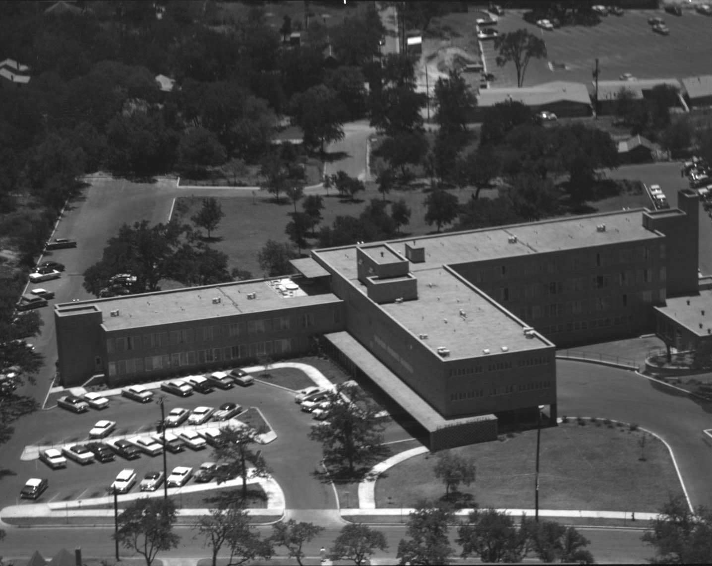 Aerial view of St. David's Hospital showing building, parking lot and part of the grounds, 1956