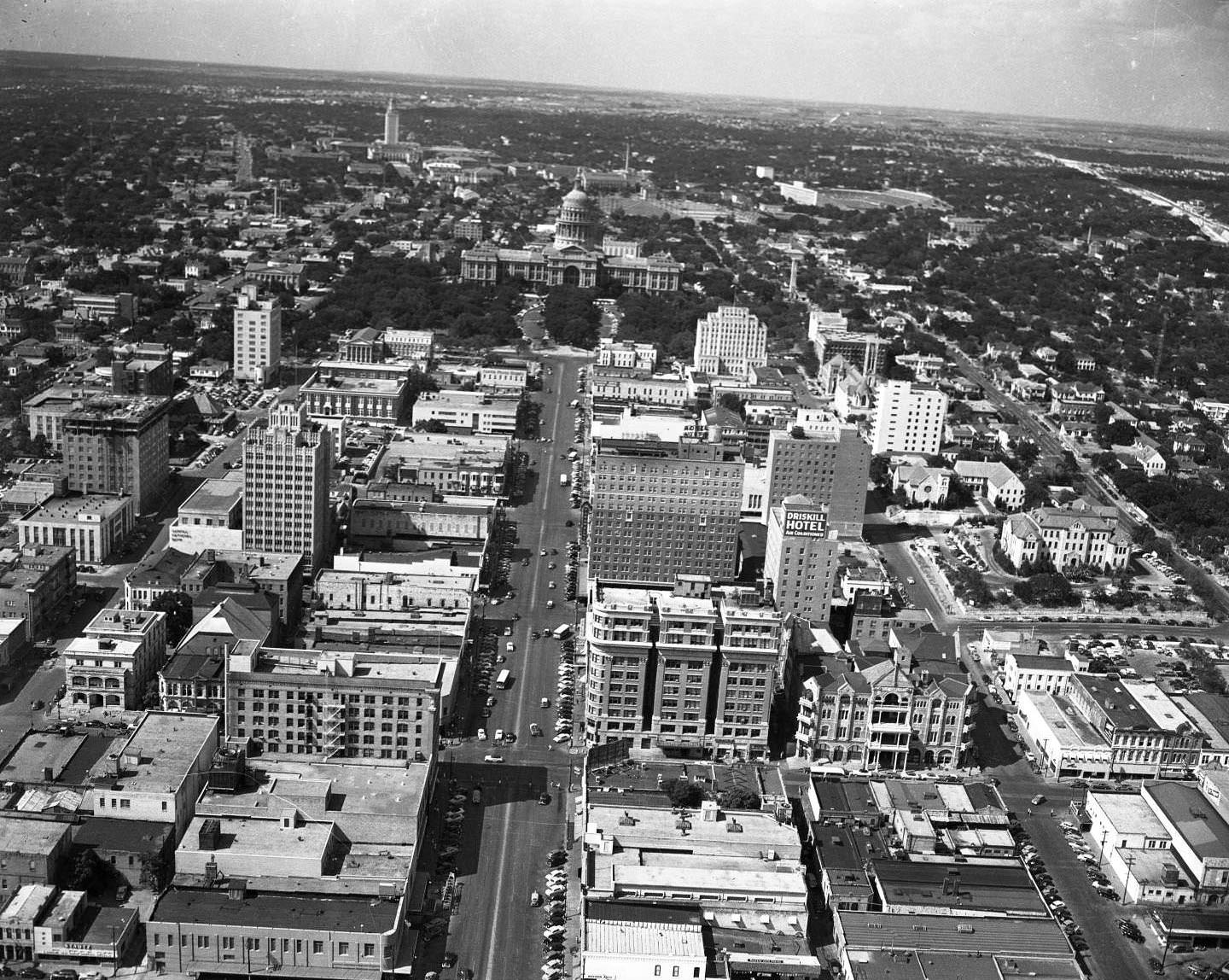 Directly south of the State Capitol and above Congress Ave., Shot of downtown Austin with The Driskill, Captiol, and UT Tower in view, 1959