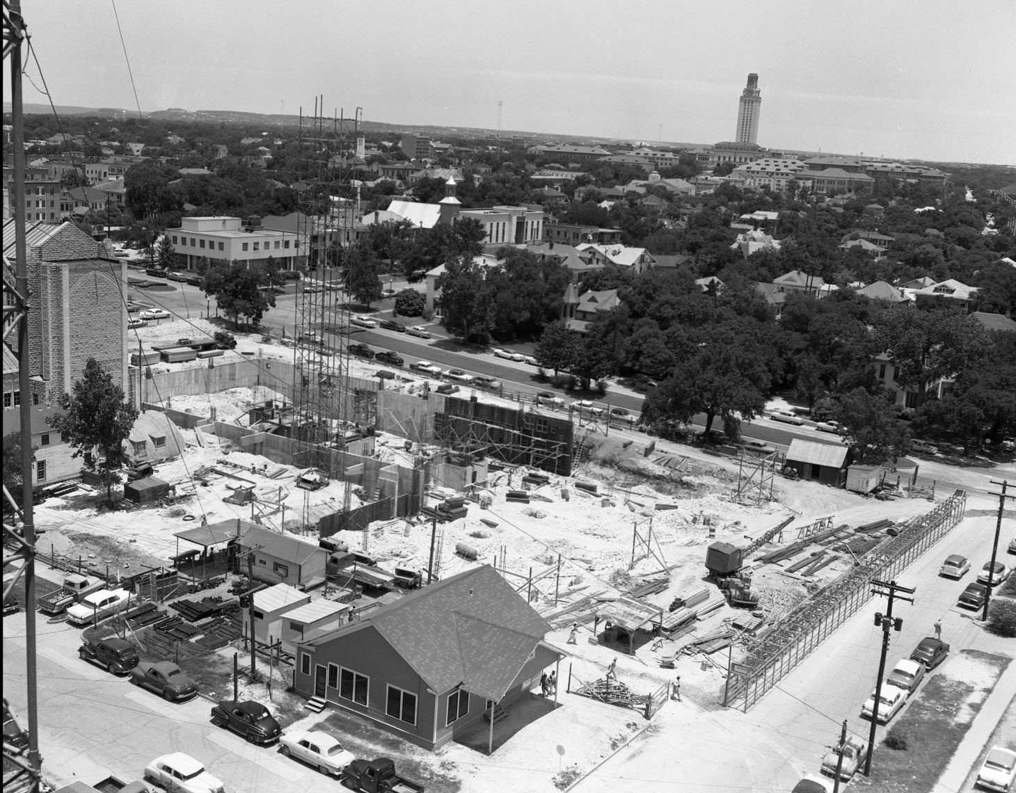 Aerial shot of cranes and scaffolding at TEC construction site. 15th Street running left to right in center of photograph, 1958