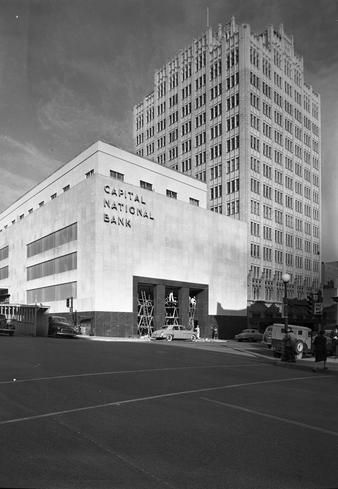 Looking northeast at the building at 114-120 W. 7th St from the intersection of 7th and Colorado St. Still under construction. Norwood Tower in view, 1951