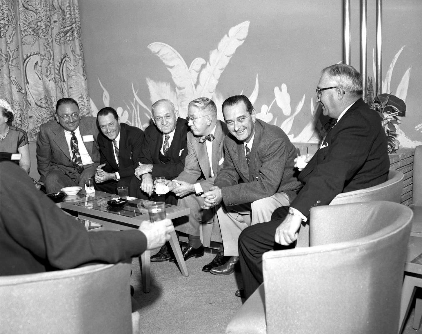 Six men seated around a small table. 5th from left is then Senator Lyndon Johnson, 1953