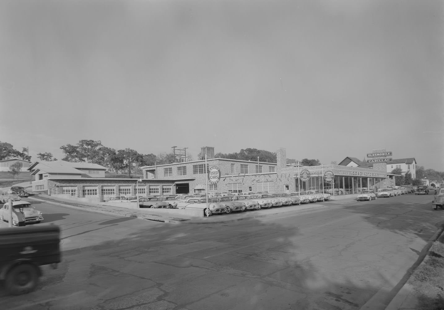 View of Goad Motor Company showroom and lot with cars, 1956