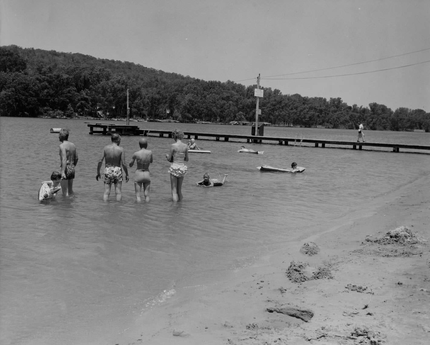 People wading and floating in the water at Lake Austin Beach, 1956