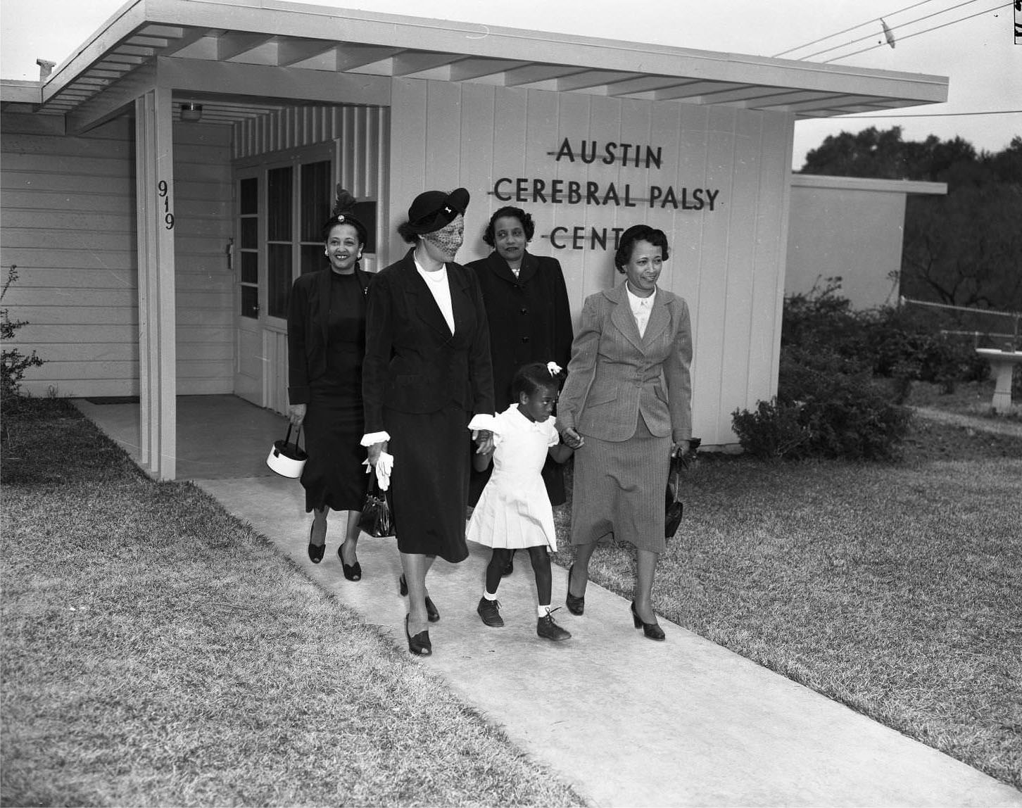 Child with adults at the Austin Cerebral Palsy Center, 1951