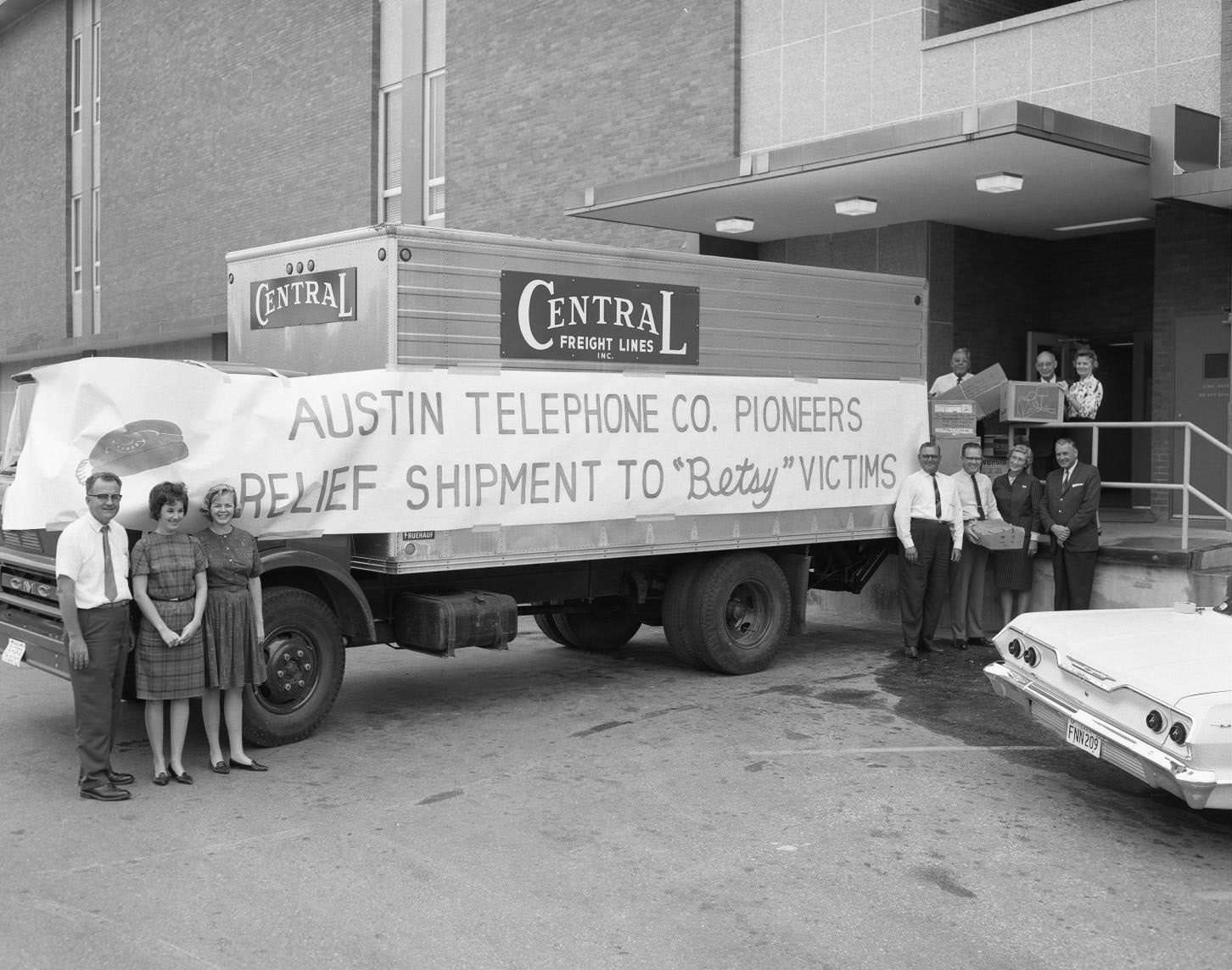 Austin Telephone Co. Pioneers stand outside relief truck, seeing off goods to the victims of Hurricane Betsy in New Orleans, 1965