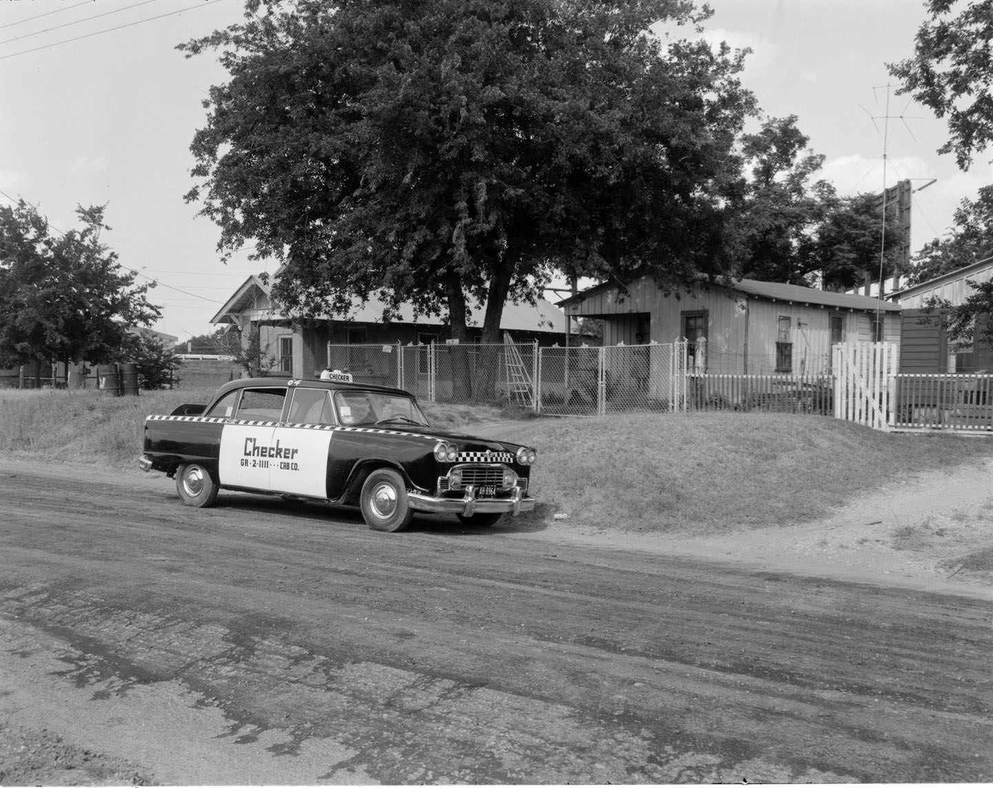Checker cab parked on a residential street, Austin, 1962