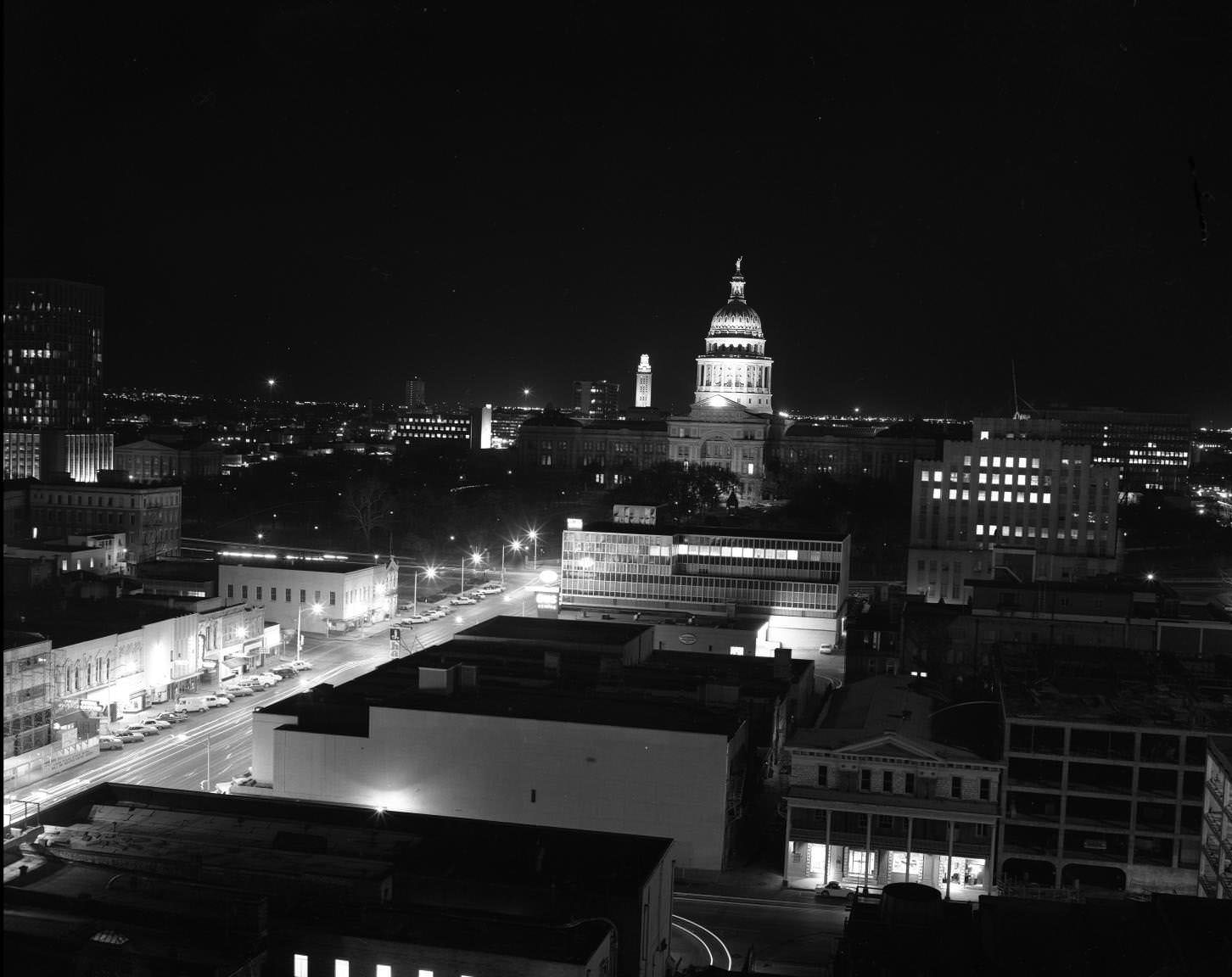Austin, Texas shot from downtown on South Congress showing the State Capitol lit up at night, 1968