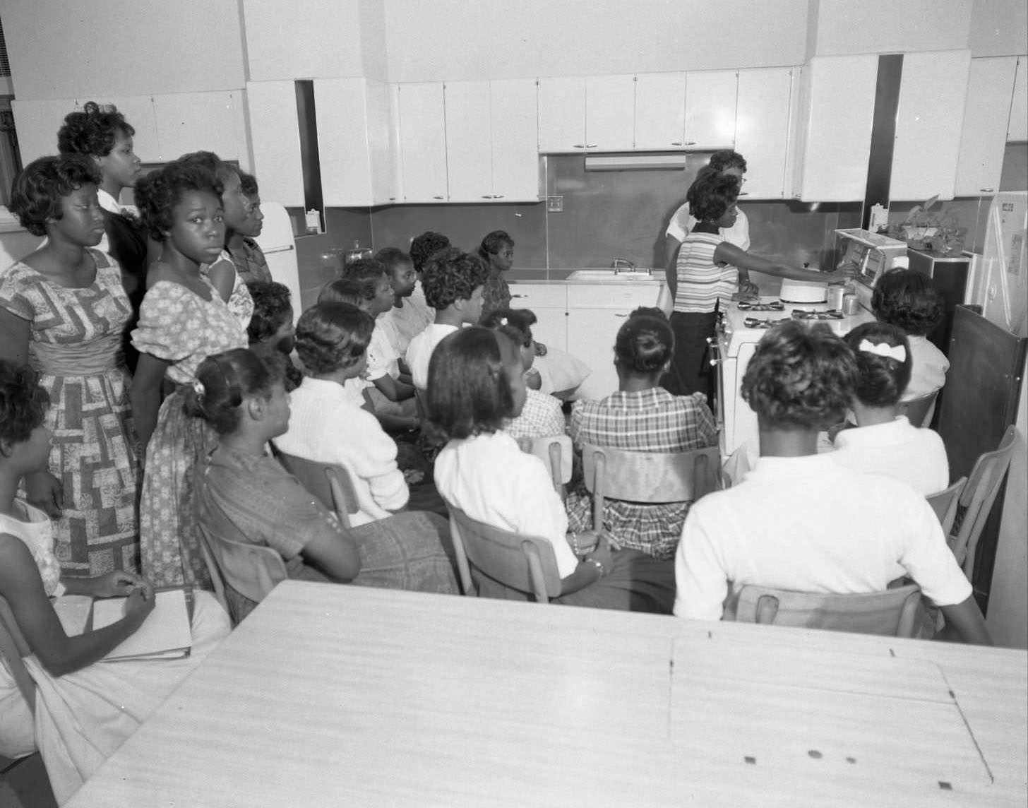 Young female students observing a kettle in a cooking class at Anderson High Schoolm, 1960