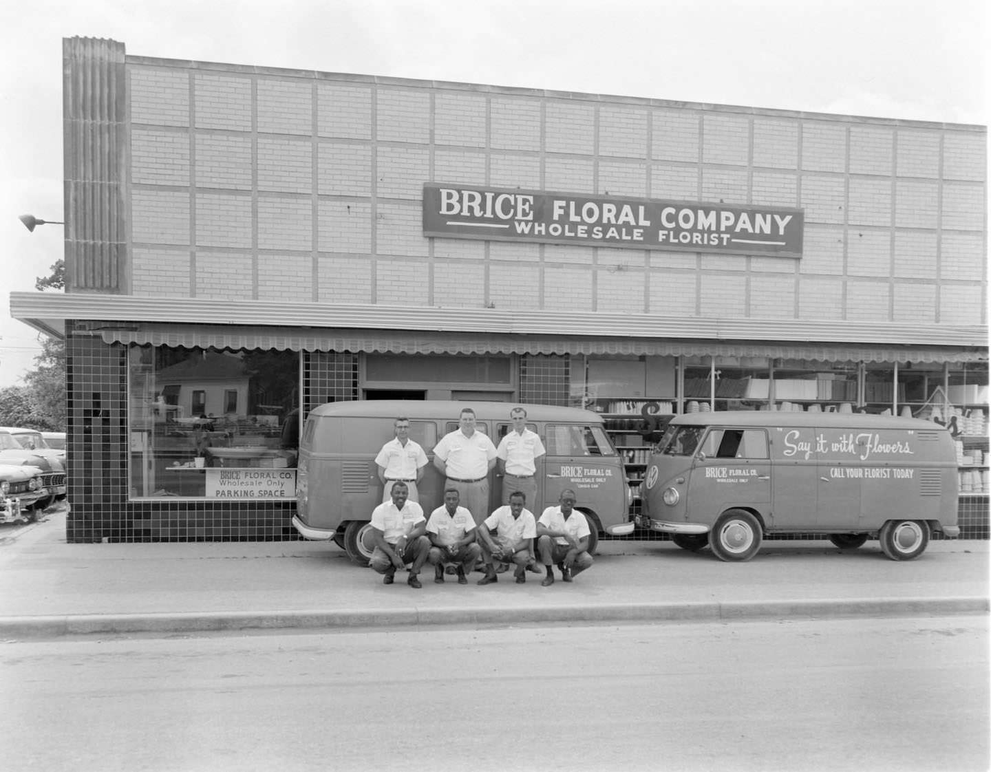 Men posing in front of vans with Brice Floral Company in background. Austin, 1930