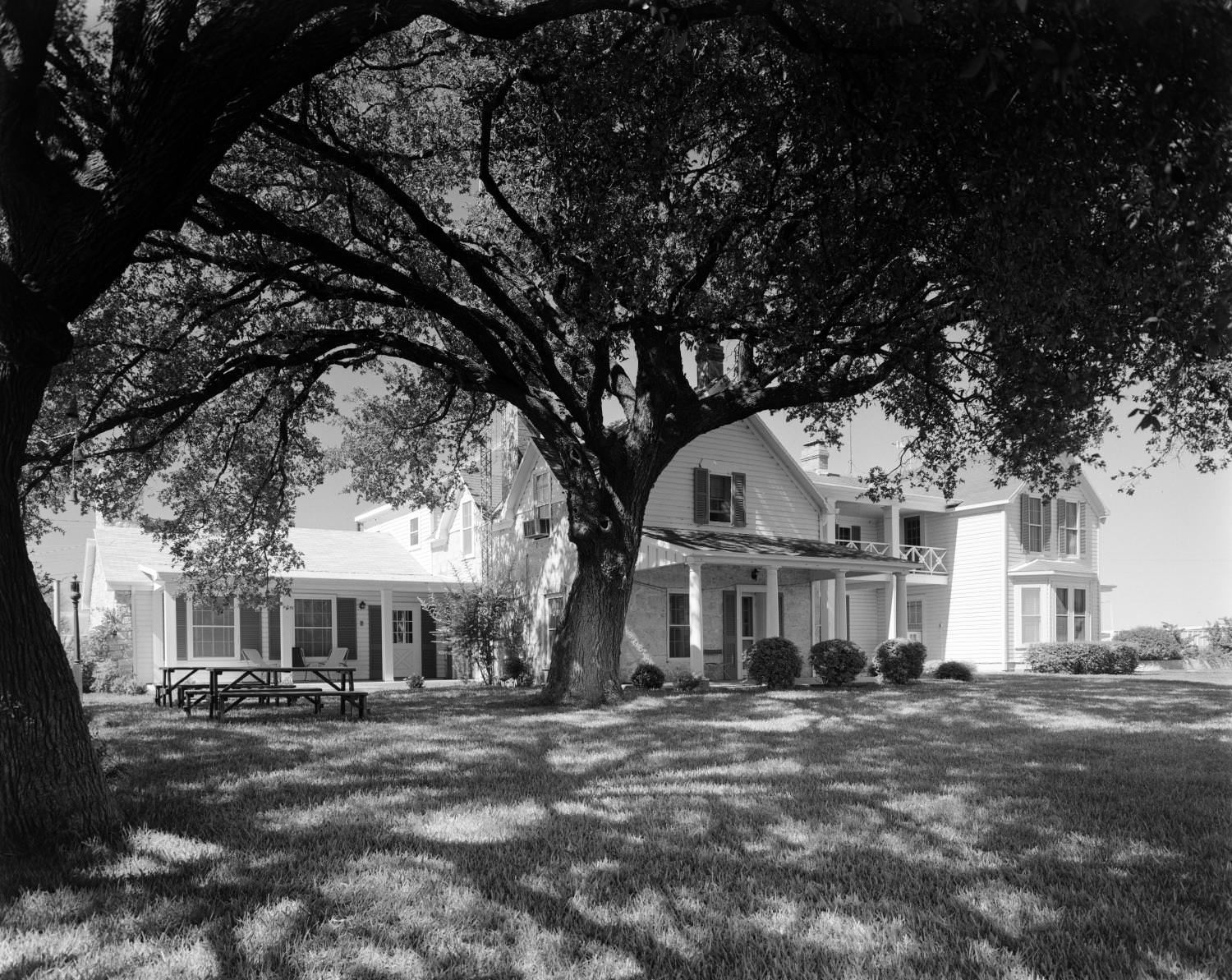 A large, two-story, white house in a late-nineteenth/early-twentieth century American style, Austin, 1960