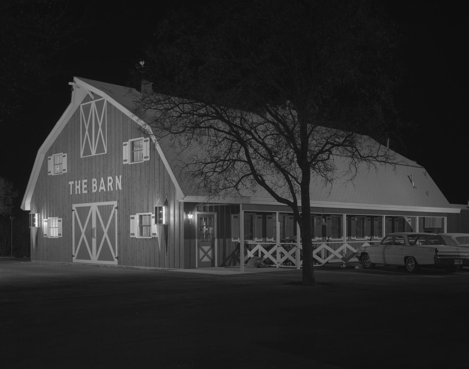 The exterior of a rustic, country themed restaurant called, The Barn, located at 8611 Balcones Drive, 1963