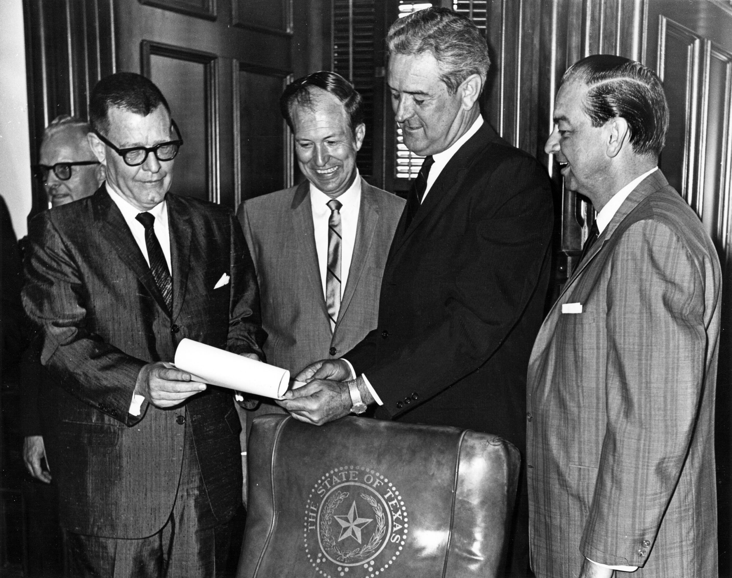 Governor John Connally holding bill for transferring Arlington State College to the University of Texas System, 1965