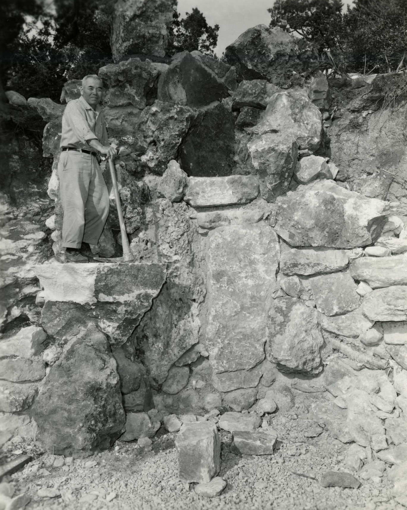 Garden architect and builder Isamu Taniguchi posing on the rocks at Zilker's Oriental Garden, 1968