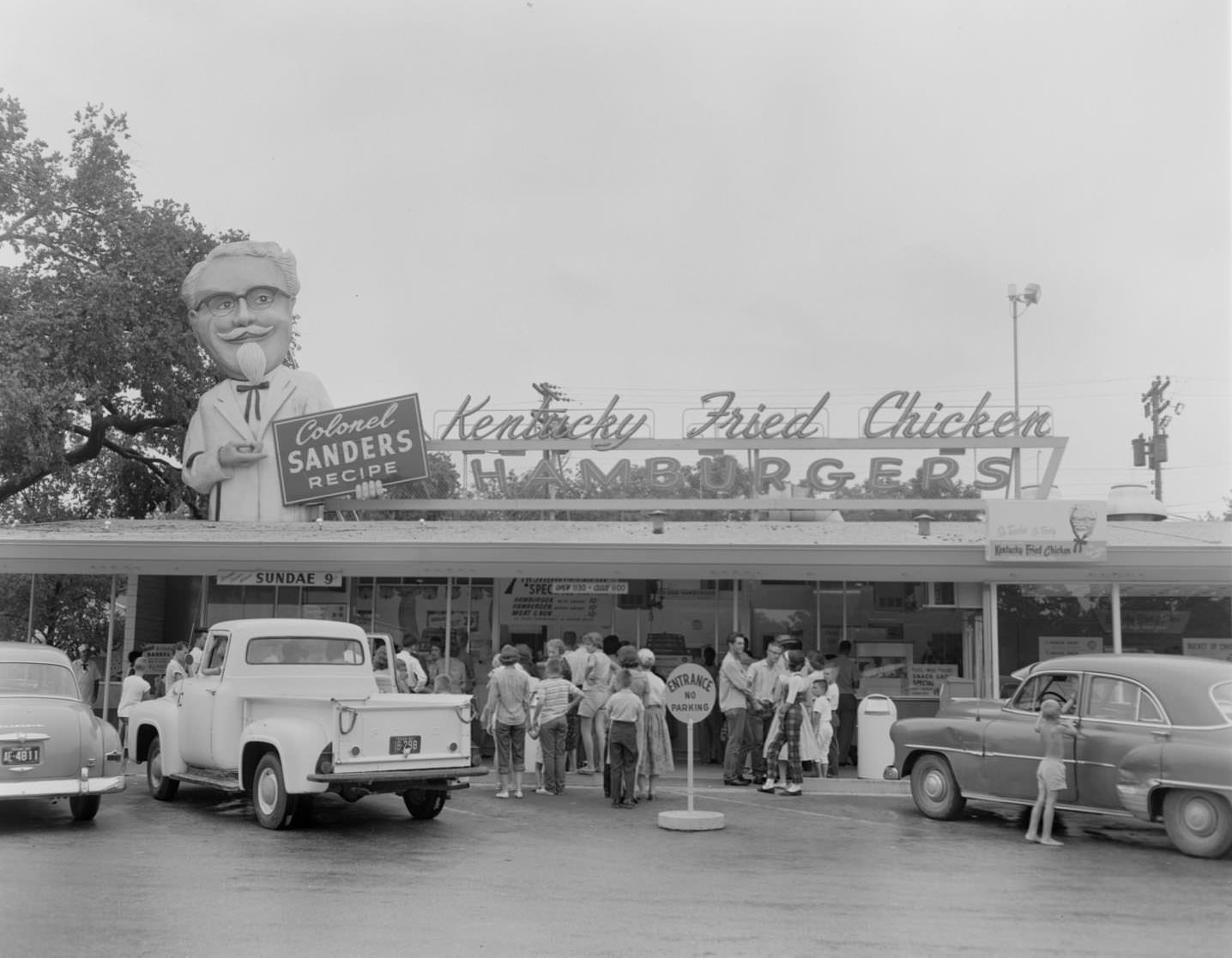 Customers and parked cars in front of Kentucky Fried Chicken stand, Austin, 1960
