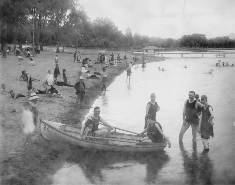 A man, woman and child sit in a rowboat near the shore of Berkeley Park beach on Berkeley Lake in Denver, 1900