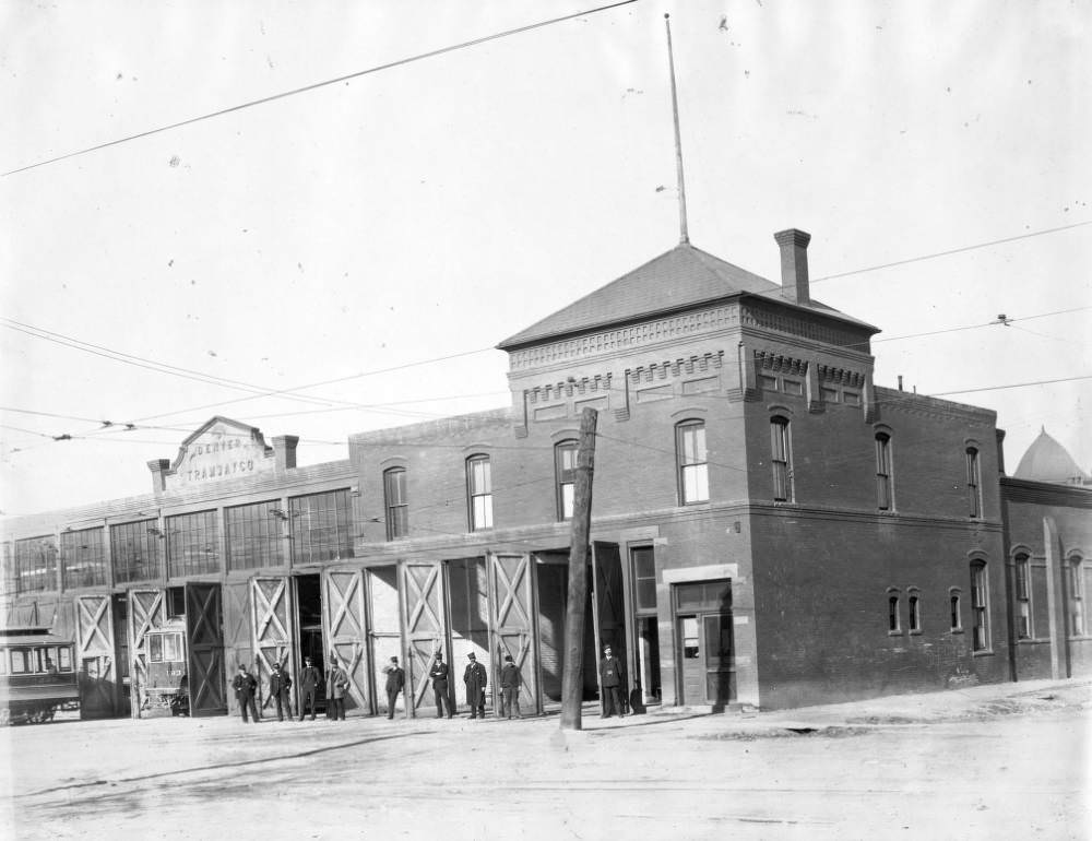 A group of conductors in uniforms pose in front of the Denver Tramway Company garage on Gilpin Street, Denver, 1905