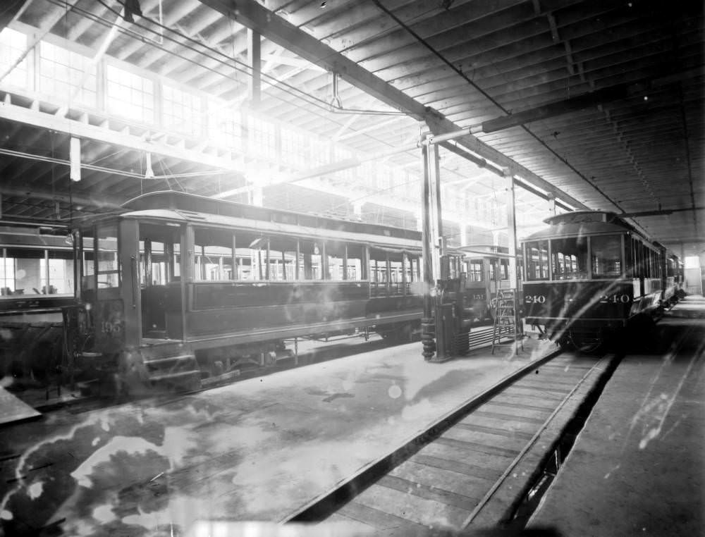 Interior of the Denver Tramway Company garage with trolleys number 195, 151, 72, and 240 at 4th (Fourth) Avenue and Kalamath Street in Denver, 1905