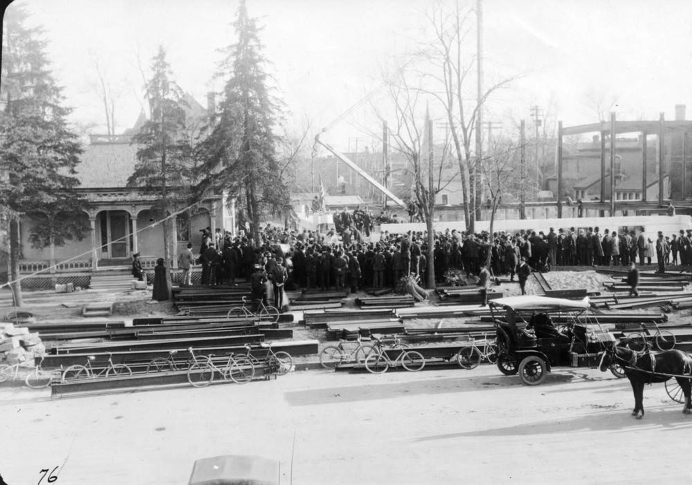 People crowd the Denver Public Library (Carnegie) construction site by a crane to watch the cornerstone ceremony in the Civic Center neighborhood of Denver, 1907