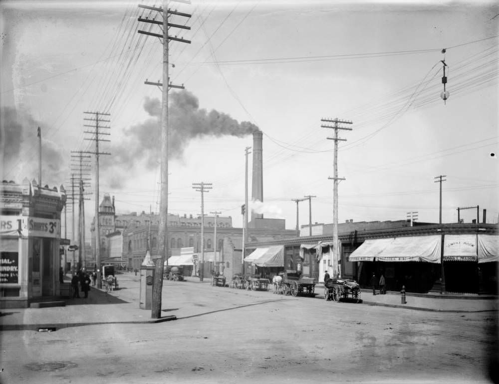 View of 18th (Eighteenth) and Arapahoe Streets with the Denver Cable Car power plant smoke stack in Denver, 1909