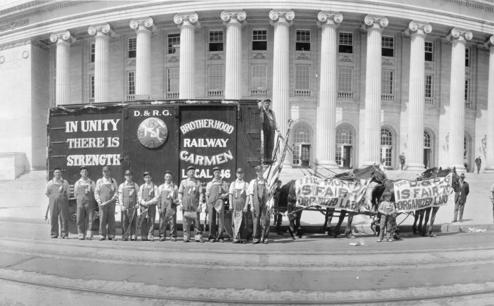 Denver and Rio Grande Railroad employees, men and boys, pose by a horse drawn railroad boxcar in front of the Stout Street Post Office, in Denver, 1909