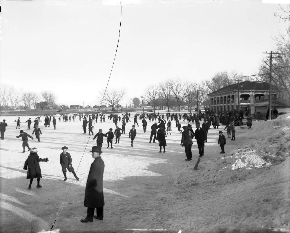 Children, women and men skate on the ice of Smith Lake at Washington Park, Denver, 1900s