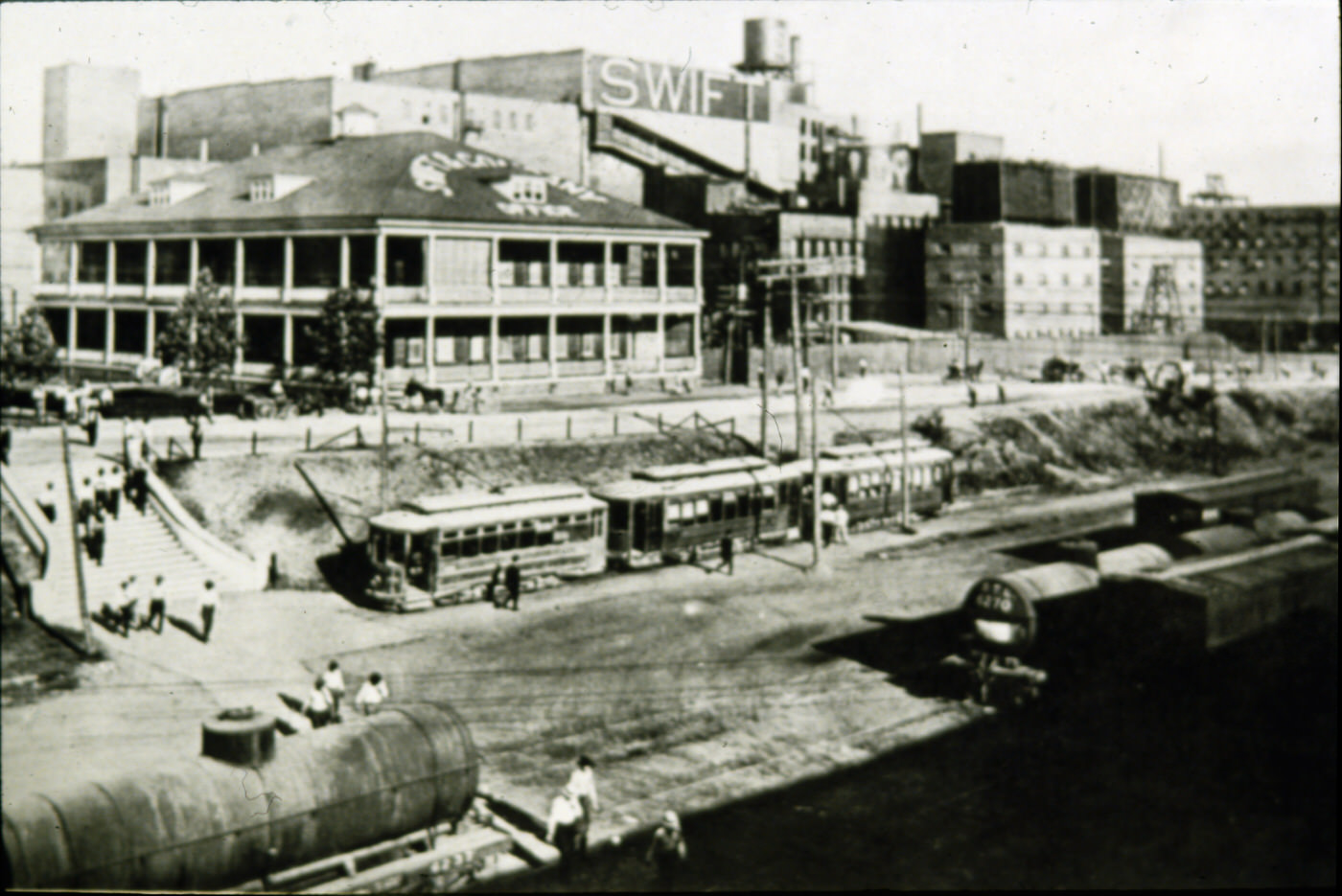 Swift & Co., Fort Worth stockyards, people disembarking from street cars and climbing stairway to meat packing plants, 1940s.