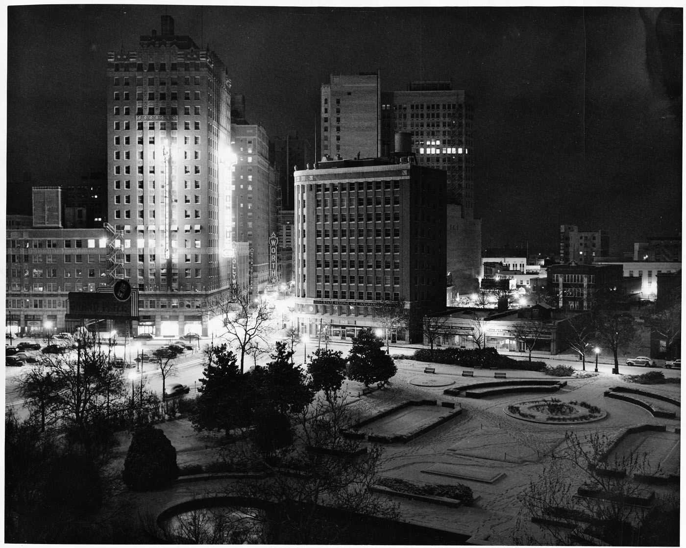 Burk Burnett Park at night in the snow, at 7th and Lamar streets; lights from surrounding buildings Texas Electric Service Company and Neil P. Anderson, 1948