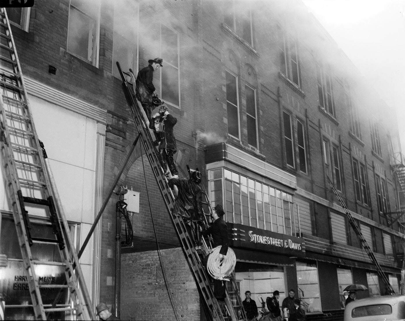 Firemen on ladder fight fire at Metropolitan Hotel building, Fort Worth, Texas, 1943
