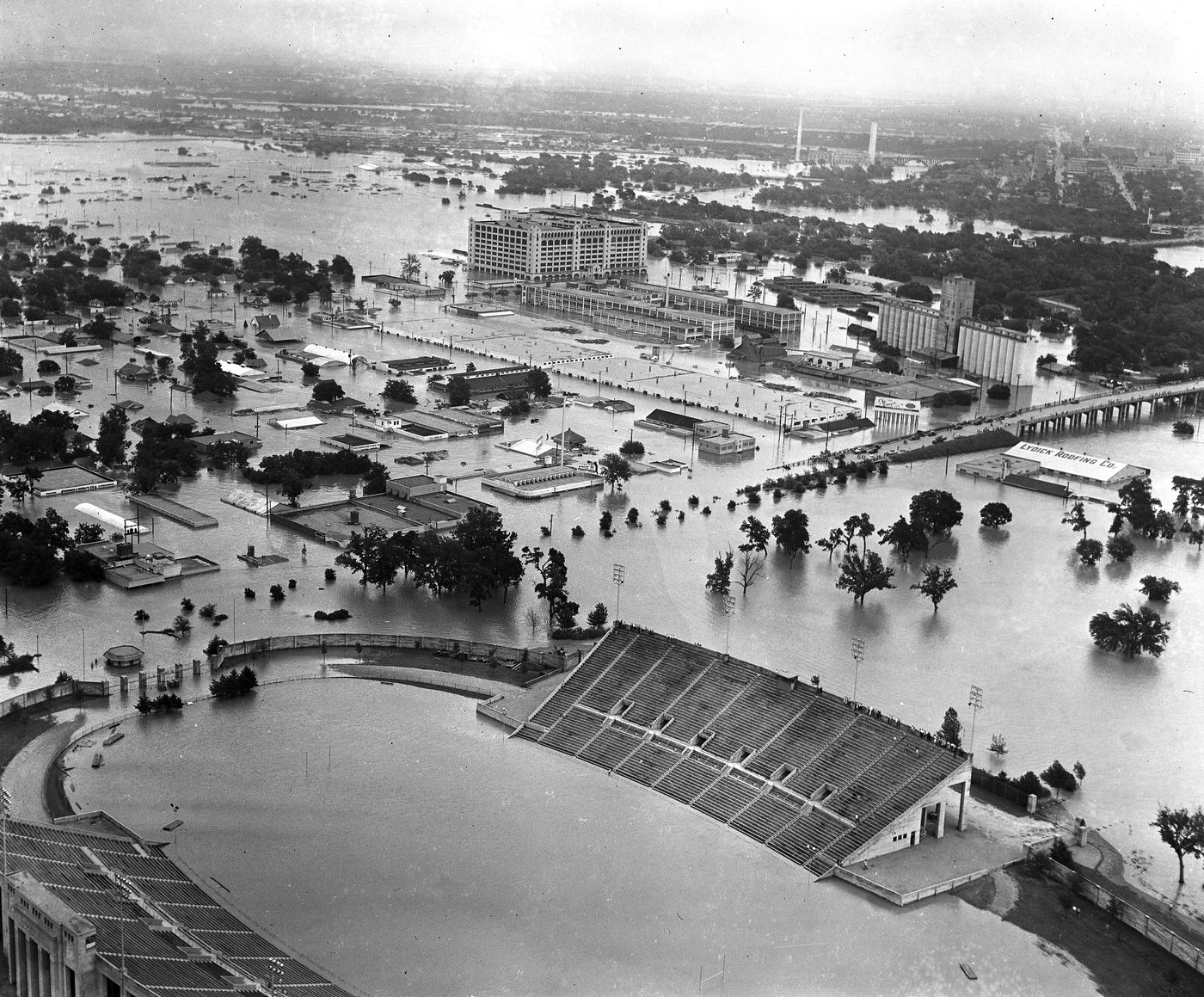Aerial of 1949 flood in Fort Worth; looking north from Farrington Field high school football stadium toward West Lancaster Street, West 7th Street, and Montgomery Ward, 1949
