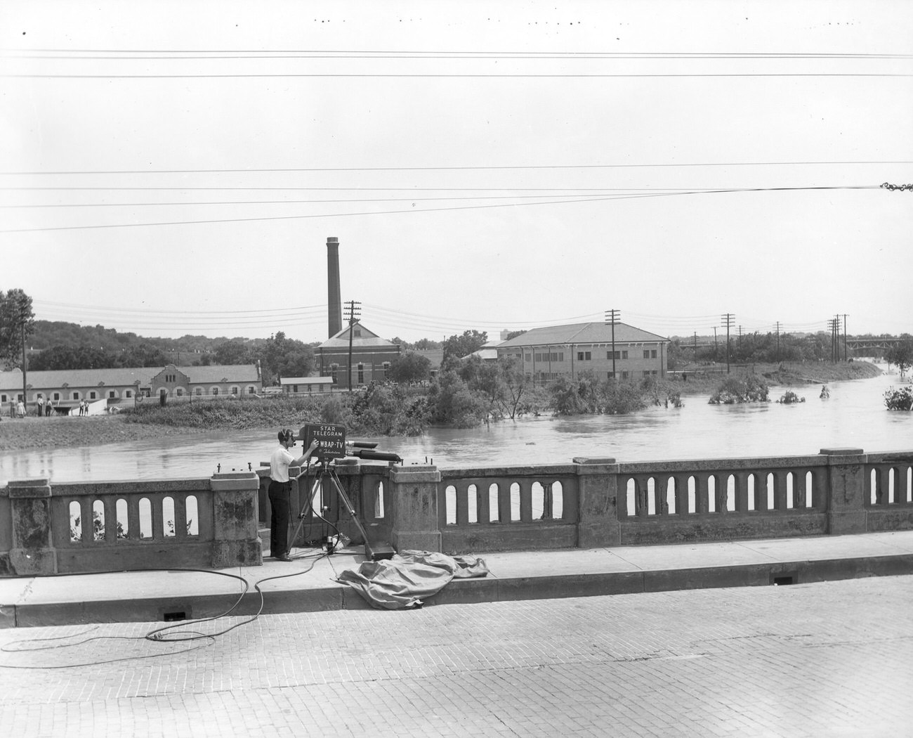 WBAP cameraman filming Trinity River flood waters from the 7th Street bridge during 1949's flood.