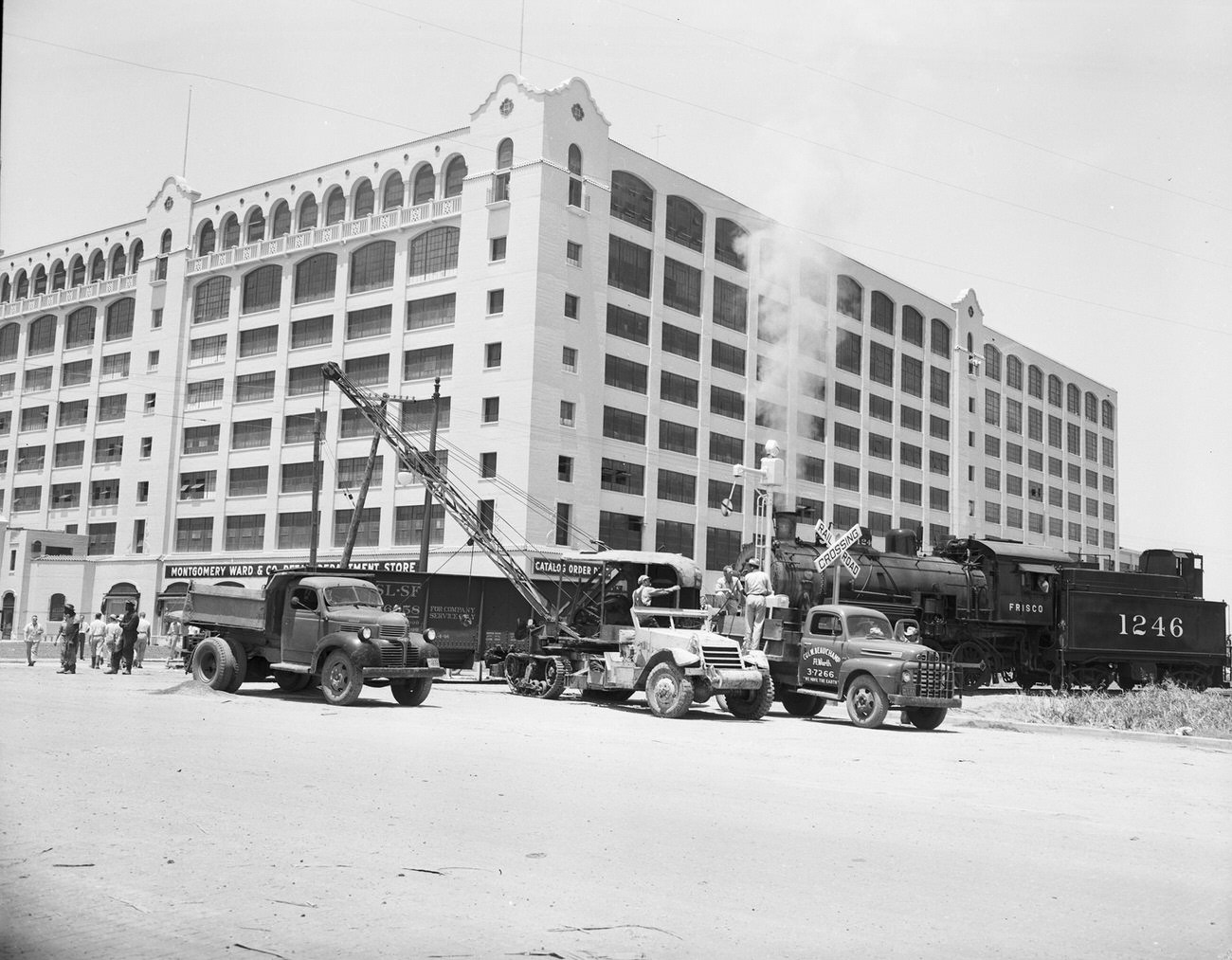 Train unloading shale in front of the Montgomery Ward building, 1949