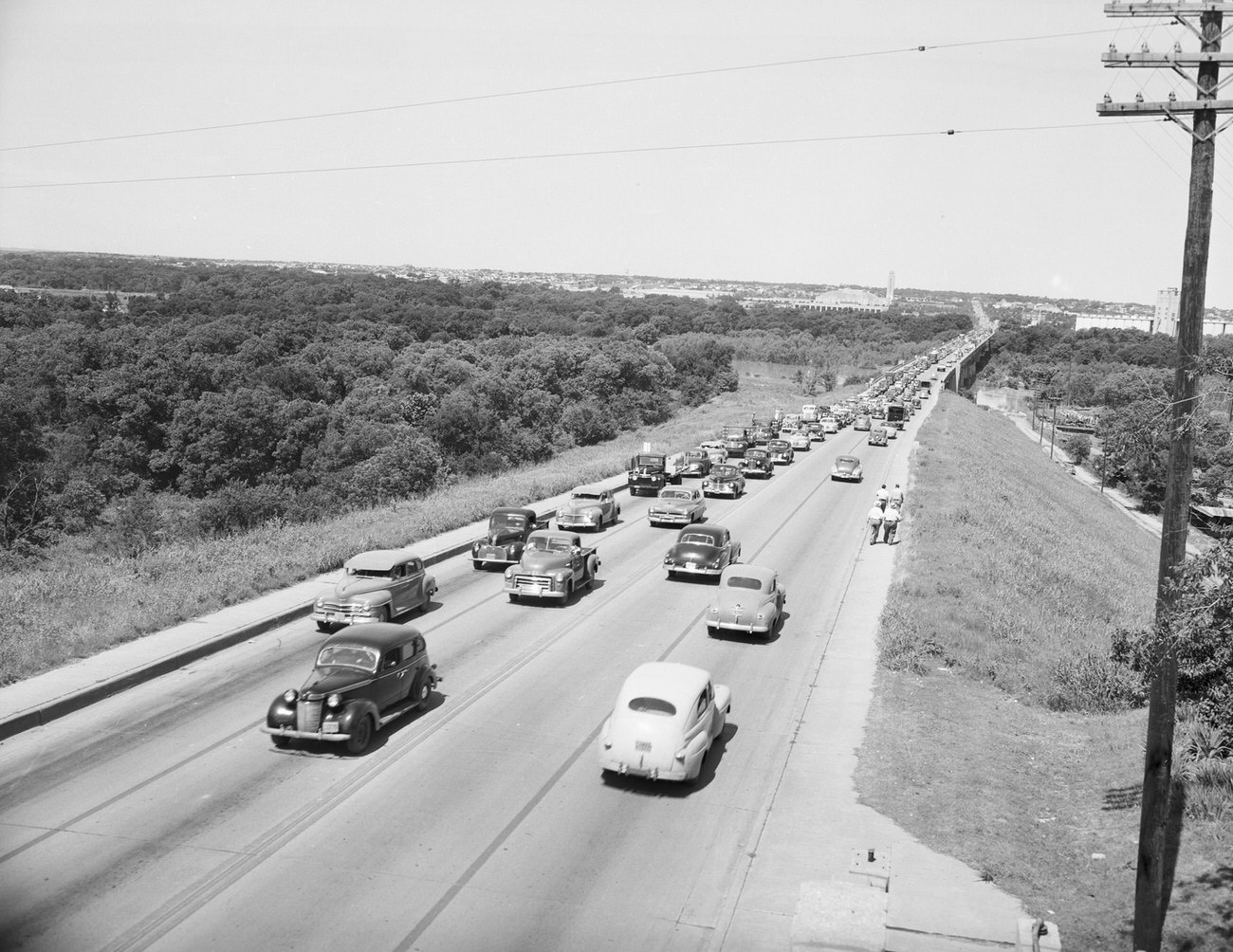 Flood Damage--Center of North Bridge. Automobiles are on the road and people are walking at the side of the street, 1949