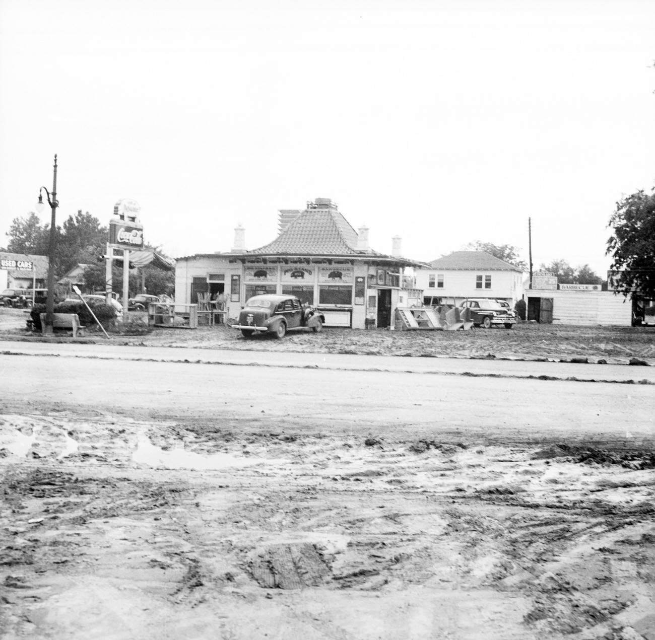 Cars parked in front of stores and shops with Coca-Cola sign in front after the 1949 Fort Worth flood.