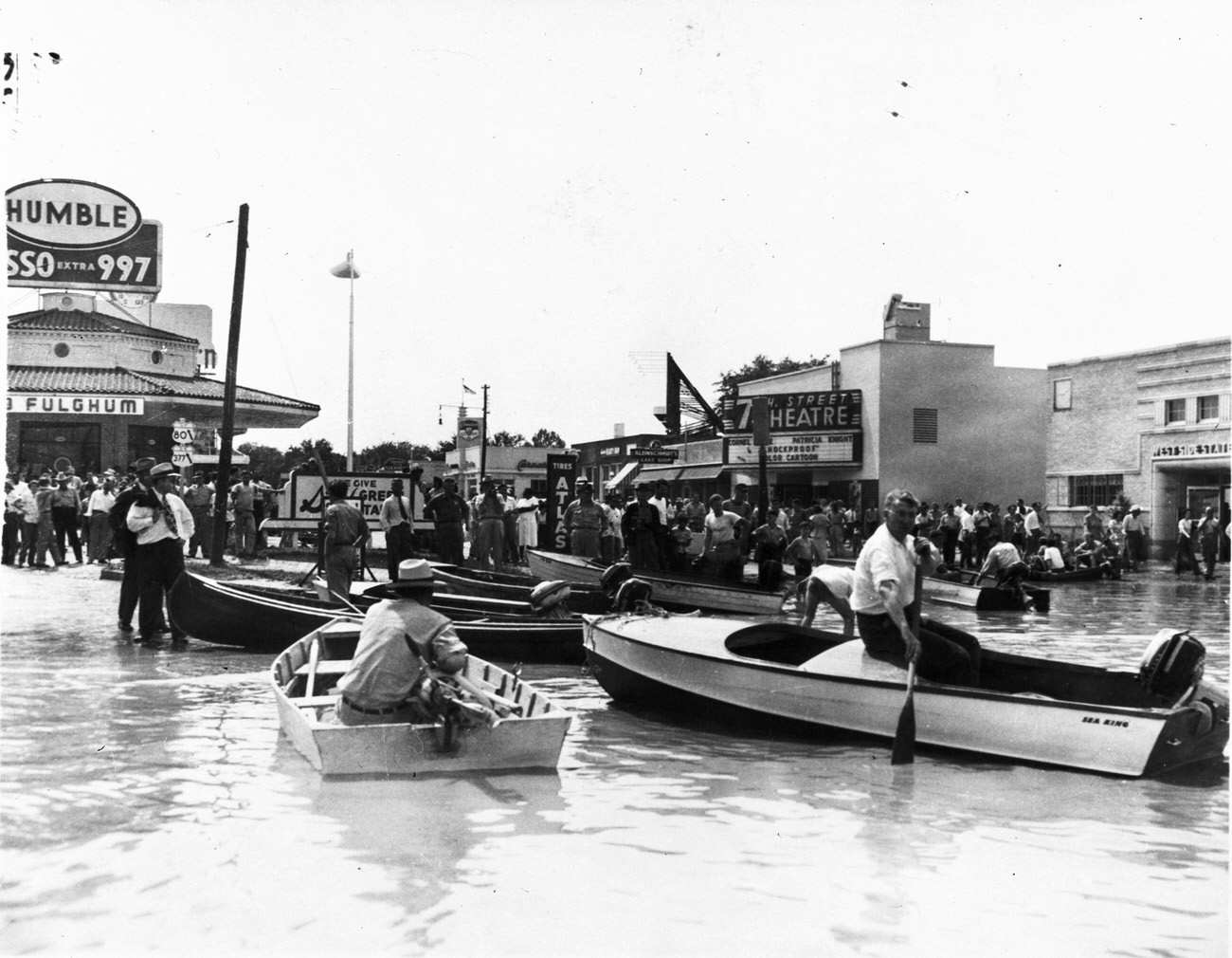 Flood at Fort Worth intersection of University and 7th Street near 7th Street Theater with people in boats, May 1949