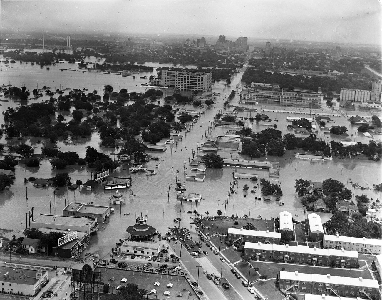 Aerial of 1949 flood in Fort Worth, Texas; looking east along West 7th Street from where University Drive. and Bailey intersect with West 7th toward Montgomery Ward, Trinity River, and downtown, 1949