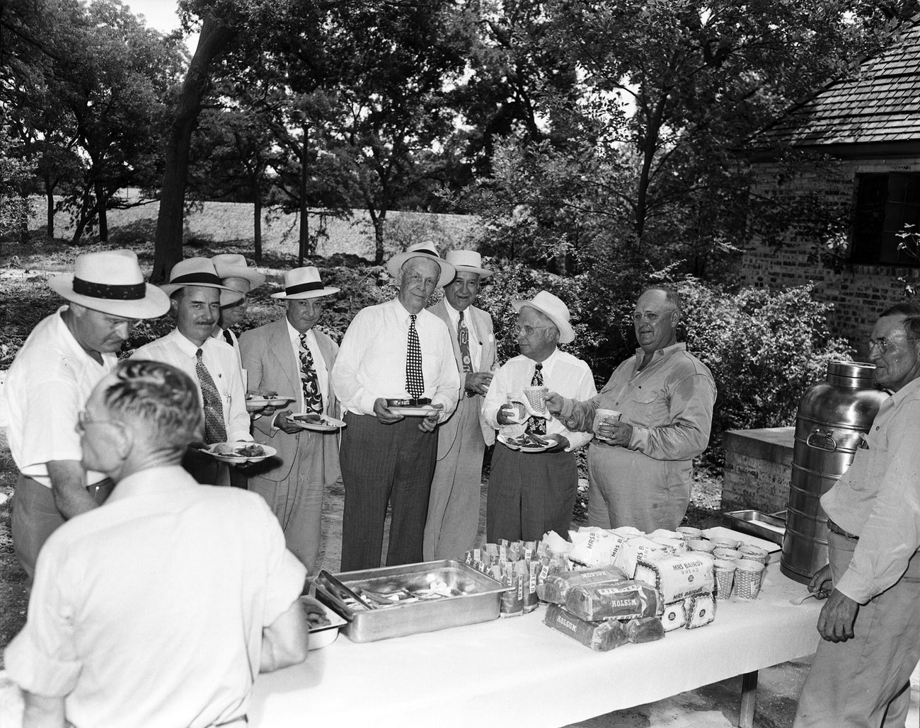 Citizens Flood Control Committee men, along with city and county officials. Amon Carter Sr. and group gathered around a picnic table.